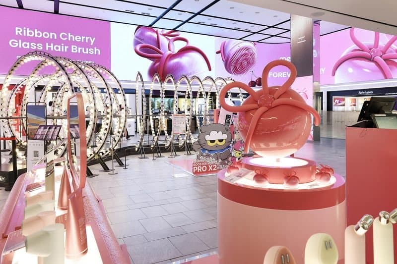 The pink medicube × Forever Cherry pop-up at Shinsegae Duty Free Myeongdong, with a giant bow-topped hairbrush display